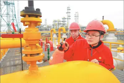  ?? ZHONG MIN / FOR CHINA DAILY ?? Workers from China National Petroleum Corp do cleaning work at a natural gas treatment facility in Suining, Sichuan province.