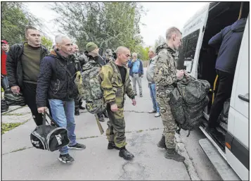  ?? The Associated Press ?? Russian recruits board a bus at a military center in Volzhskiy, Volgograd region, Russia, on Wednesday. The reservists are intended to beef up forces in Ukraine.
