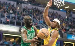  ?? AJ MAST/AP ?? Celtics guard Jaylen Brown passes the ball around Pacers center Myles Turner during the first half Thursday in Indianapol­is.