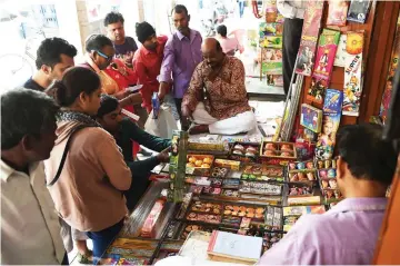  ?? — AFP photo ?? Indian customers visit a firecracke­r shop in New Delhi.