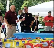  ??  ?? LEFT: Rome police Pfc. Don Davis (left) and Maj. Rodney Bailey catch up near the table of chips and sides Tuesday during the Thank A Hero Rome Luncheon at the RomeFloyd County Fire Department’s training center Tuesday.