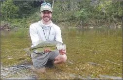  ?? NWA Democrat-Gazette/FLIP PUTTHOFF ?? Roberts shows a largemouth bass he caught fly fishing on Little Sugar Creek.