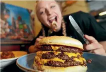  ?? PHOTO: FAIRFAX NZ ?? Virginia Nicolson shows off the Reaper Burger, Geraldine Central Licensed Cafe’s latest challenge to brave diners.