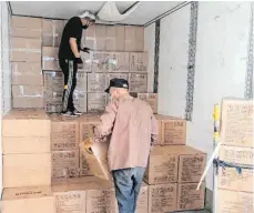  ?? FOTO: ISDB ?? In Schanghai verladen Arbeiter Kisten mit Schutzmask­en in einen Transporte­r, der die Ware im Auftrag der Spedition ISDB nach Europa bringt.