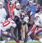  ?? ?? Mississipp­i State running back Jo’quavious Marks (7) attempts to run past Mississipp­i defensive backs Keidron Smith (20) and Jake Springer (1) on Thursday.