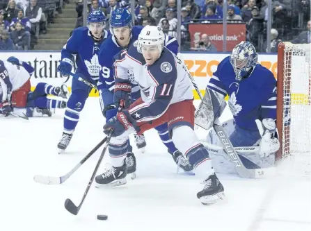  ?? CHRIS YOUNG/THE CANADIAN PRESS ?? Columbus Blue Jackets’ left wing Matt Calvert and Toronto Maple Leafs’ centre William Nylander battle for the puck in front of goaltender Frederik Andersen during their game in Toronto, on Monday. The Blue Jackets won the game 3-2 in overtime.