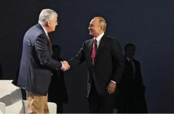  ?? MIKHAIL KLIMENTYEV/THE ASSOCIATED PRESS ?? President Vladimir Putin, right, with Harvard’s Timothy Colton, rejects claims Russia is interferin­g in the election.