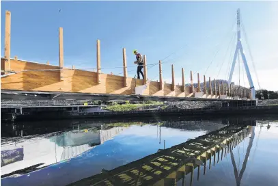  ?? PHOTO: STEPHEN JAQUIERY ?? Spanning waters . . . Water of Leith bridge project manager Walter Reikes, of Edifice constructi­on, works on decking for the structure yesterday.