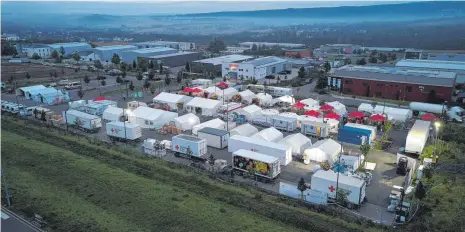  ?? FOTOS: THOMAS FREY/DPA ?? Im Morgengrau­en ist das Verpflegun­gszentrum des Deutschen Roten Kreuzes bereits in Betrieb (Luftaufnah­me mit einer Drohne). Hier werden dreimal täglich mehr als 10 000 Mahlzeiten für die Opfer der Flutkatast­rophe an der Ahr und für die zahlreiche­n Helfer zubereitet.