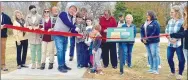  ?? Photo by Greater Gravette Chamber of Commerce ?? Karen Benson (red sweater), Gravette library director, looks on as Samuel, Elijah, Noah and Abigail Holloway assist Gravette Mayor Kurt Maddox in cutting the ribbon at the StoryWalk in Hiwasse Park. Others present included Chamber of Commerce president Steve Harari, library assistants Artemis Edmisten and Brittany Mangold, police chief Chuck Skaggs, Zina Weihe, member of the Hiwasse Committee, and members of the Hiwasse community.