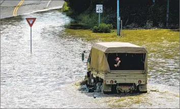  ?? Noah Berger Associated Press ?? A TRUCK navigates f loodwaters in Pajaro. Across Northern California, the Central Valley and the Sacramento- San Joaquin River Delta, there are more than 13,000 miles of levees designed to protect dry land.