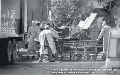  ?? JOHN H. WHITE/SUN-TIMES FILE ?? Workers bring in bodies from refrigerat­ed trucks parked outside the Cook County medical examiner’s office on July 17, 1995.