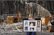  ?? RICH PEDRONCELL­I / AP / FILE ?? In 2019, Christina Taft, the daughter of Camp Fire victim Victoria Taft, displays photos of her mother, at the ruins of the Paradise, Calif., home.
