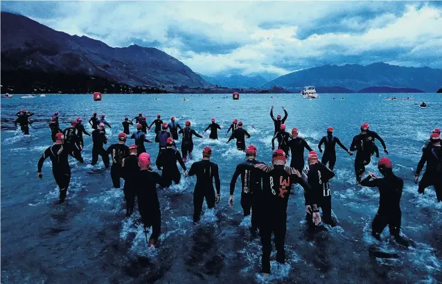  ?? PHOTO: GETTY IMAGES ?? Starting splash . . . Competitor­s enter the lake for the start of Challenge Wanaka on Saturday.
