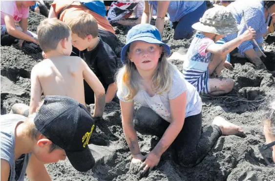  ?? Photos / Stuart Munro ?? Olivia Jackson, 8, was one of hundreds digging for prizes at Kai Iwi Beach during a fundraisin­g day for the Whanganui Surf Lifeguard Service.
