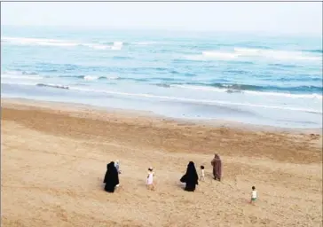 ?? EMILY IRVING-SWIFT/AFP ?? Moroccan women wear the niqab while walking on the beach with their children in Casablanca on August 12.