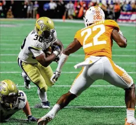  ?? CURTIS COMPTON / CCOMPTON@AJC.COM ?? Tech’ KirVonte Benson runs for some of his 124 yards on 26 carries against Tennessee on Monday. The Yellow Jackets finished with 535 yards rushing.