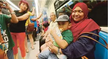  ??  ?? ANTARA ibu bapa yang membawa keluarga bersiar-siar di ibu kota menggunaka­n pengangkut­an MRT.