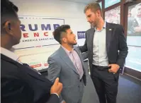  ?? DAVID WALLACE/ THE REPUBLIC ?? Olympian Henry Cejudo, center, who attended Maryvale High School in Phoenix, talks with Eric Trump, right, at the Latinos for Trump south Phoenix field office.