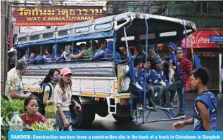  ?? ?? BANGKOK: Constructi­on workers leave a constructi­on site in the back of a truck in Chinatown in Bangkok on January 3, 2024. — AFP