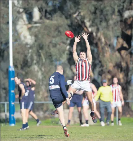  ??  ?? A Heathcote footballer tries to put off Mt Pleasant’s Nick Grigg as he shoots for goal.