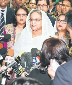  ??  ?? Hasina (centre) speaks to the media after casting her vote at a polling station in Dhaka. — AFP photo