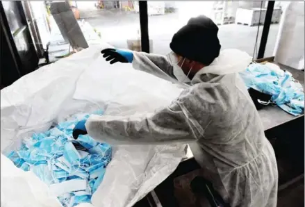  ?? AFP ?? An employee sorts used masks at the Greenwishe­s waste sorting centre in Gennevilli­ers near Paris on April 19.