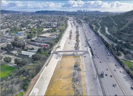  ?? THE LOS ANGELES RIVER Allen J. Schaben Los Angeles Times ?? runs high during a break in February’s rain. L.A. County officials are working to capture more rainwater.