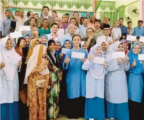  ?? PIC BY NOORAZURA ABDUL RAHMAN ?? Education Minister Datuk Seri Mahdzir Khalid (centre) with recipients of aid and scholarshi­ps at SMK Kuala Nerang yesterday.