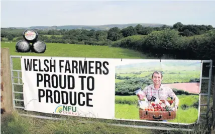  ??  ?? > NFU Cymru’s Proud to Produce gate banner and bale sticker campaign