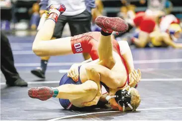  ?? Diana L. Porter / For the Chronicle ?? Oak Ridge’s Spencer Reynolds, top, tries to pin Cameron Mitchell of Clear Lake in the 145-lb. class match at the Region III-6A Boys Wrestling Championsh­ips last week.