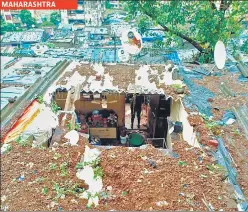  ?? REUTERS/ANI ?? (Top) People travel in a boat through a flooded field in Assam’s Morigaon district on Wednesday. (Above) The roof of a house collapsed due to a landslide after heavy rainfall in Thane.