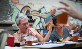  ?? Tribune News Service ?? Ann McCully of Minneapoli­s sings along during a Beer Choir Twin Cities get together.