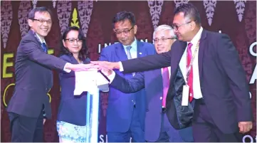  ??  ?? Abdul Karim (centre) together with (from left) Wong, Sabariah, Khairuddin and Fadzilah place their palms on the tablet to launch InHERIT 2018. — Photo by Muhammad Rais Sanusi