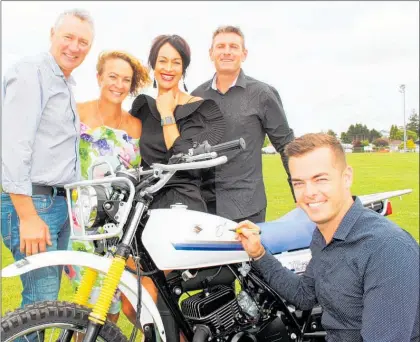  ?? Photo / Cathy Asplin ?? Supercars champion Scott McLaughlin writes on the tank of a Suzuki Mudbug, donated by Ilana Wilks and Mark Penny (right). After the auction new owners Allan and Jan Mockford (left) plan to replace the tank of their new farm bike so they can keep Scott’s message in pristine condition.