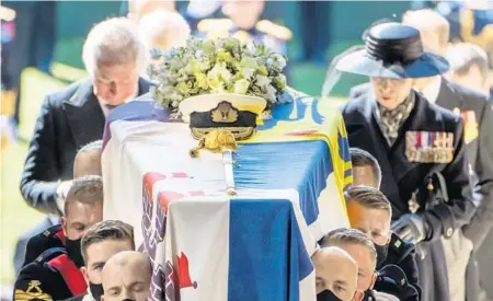  ?? DANNY LAWSON/GETTY ?? Princess Anne and Prince Charles follow the coffin of Prince Philip as it is carried into his funeral service Saturday at St. George’s Chapel in Windsor, England. The royal procession and funeral was shown live on television. Only 30 people were allowed in the chapel due to coronaviru­s restrictio­ns.