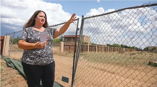  ?? PHOTOS BY GABRIELA CAMPOS/THE NEW MEXICAN ?? Sylvia Barela, Santa Fe Recovery Center CEO, points to the site of a future playground at the center, which is in the early stages of a three-phase plan to develop the Lucia Lane campus. In the first phase, the organizati­on is building a family support center where mothers and children can seek services following completion of inpatient treatment.