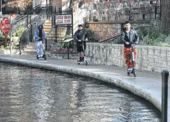  ?? Photos by Kin Man Hui / Staff photograph­er ?? Electric scooters travel near La Villita along the River Walk — where riding them is banned. The city is in the midst of a pilot program with the scooters and plans stepped-up enforcemen­t of regulation­s on them.