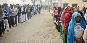  ?? — Reuters ?? People queue to vote during the state assembly election, in the town of Deoband in Uttar Pradesh on Wednesday.