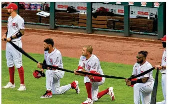  ?? DAVID JABLONSKI / STAFF ?? Eugenio Suarez (from left), Joey Votto and Phillip Ervin of the Cincinnati Reds kneel during a pregame ceremony paying tribute to the Black Lives Matter movement on Opening Day on Friday at Great American Ball Park in Cincinnati.