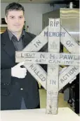  ?? FILE ?? Tim Cook, acting director of research at the Canadian War Museum, displays the Norman Howard Pawley cross, first erected after the Battle of Vimy Ridge in 1917.