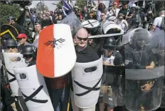  ??  ?? White nationalis­t demonstrat­ors use shields Aug. 12 as they guard the entrance to Lee Park in Charlottes­ville, Va.