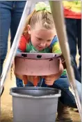  ??  ?? Taylor Mauldin, 7, of Westfield Elementary School, tries milking a model cow on Friday.