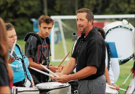  ?? KRISTI GARABRANDT — THE NEWS-HERALD ?? Steve Poremba, director of the Mentor High School Marching Band, works with the percussion section of the band during practice.