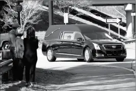  ?? ASSOCIATED PRESS ?? PEOPLE VIEW AND PHOTOGRAPH THE HEARSE CARRYING the remains of the Rev. Billy Graham as it arrives at the Billy Graham Training Center at the Cove on Thursday in Asheville, NC. WHY BILLY GRAHAM GETS THE HONOR