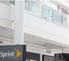  ?? AFP ?? In this file photo, the T-Mobile logo and Sprint logo are seen outside shops in Washington.