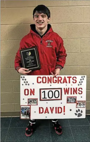  ?? PHOTO COURTESY BOYERTOWN ATHLETICS ?? Boyertown’s David Campbell poses with a congratula­tory sign after securing his 100th win of his high school career at the Cumberland Valley Winter Duals. The Bears finished second, falling to Northampto­n in the championsh­ip match.