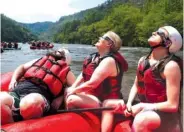  ?? STAFF PHOTO BY ERIN O. SMITH ?? Matthew O’Brien, Christina O’Brien and Logan Brockway watch the eclipse Monday from a Big Frog Expedition­s raft on the Ocoee River in Polk County, Tenn.