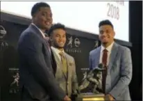  ?? RALPH RUSSO — THE ASSOCIATED PRESS ?? Heisman Trophy finalists, from left, Dwayne Haskins, from Ohio State, Kyler Murray, of Oklahoma, and Tua Tagovailoa, from Alabama, pose with the Heisman Trophy at the New York Stock Exchange on Friday.