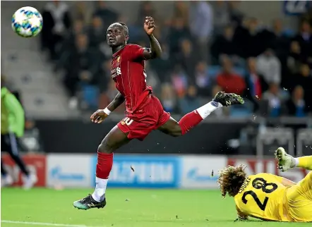  ?? GETTY IMAGES ?? Liverpool striker Sadio Mane scores his side’s third goal in the 4-1 win over Genk.